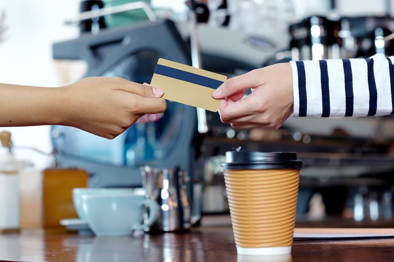 Woman using card at coffee shop